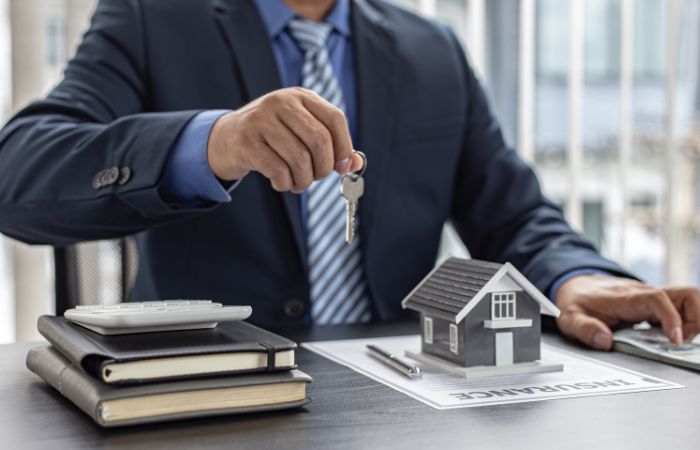 Person holding a model house representing property management